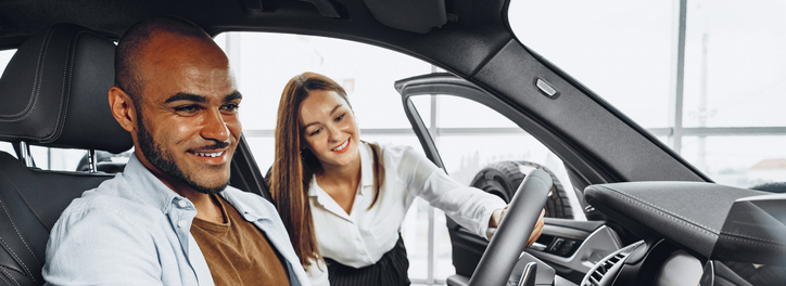 Automotive sales person showing an electric vehicle to a customer